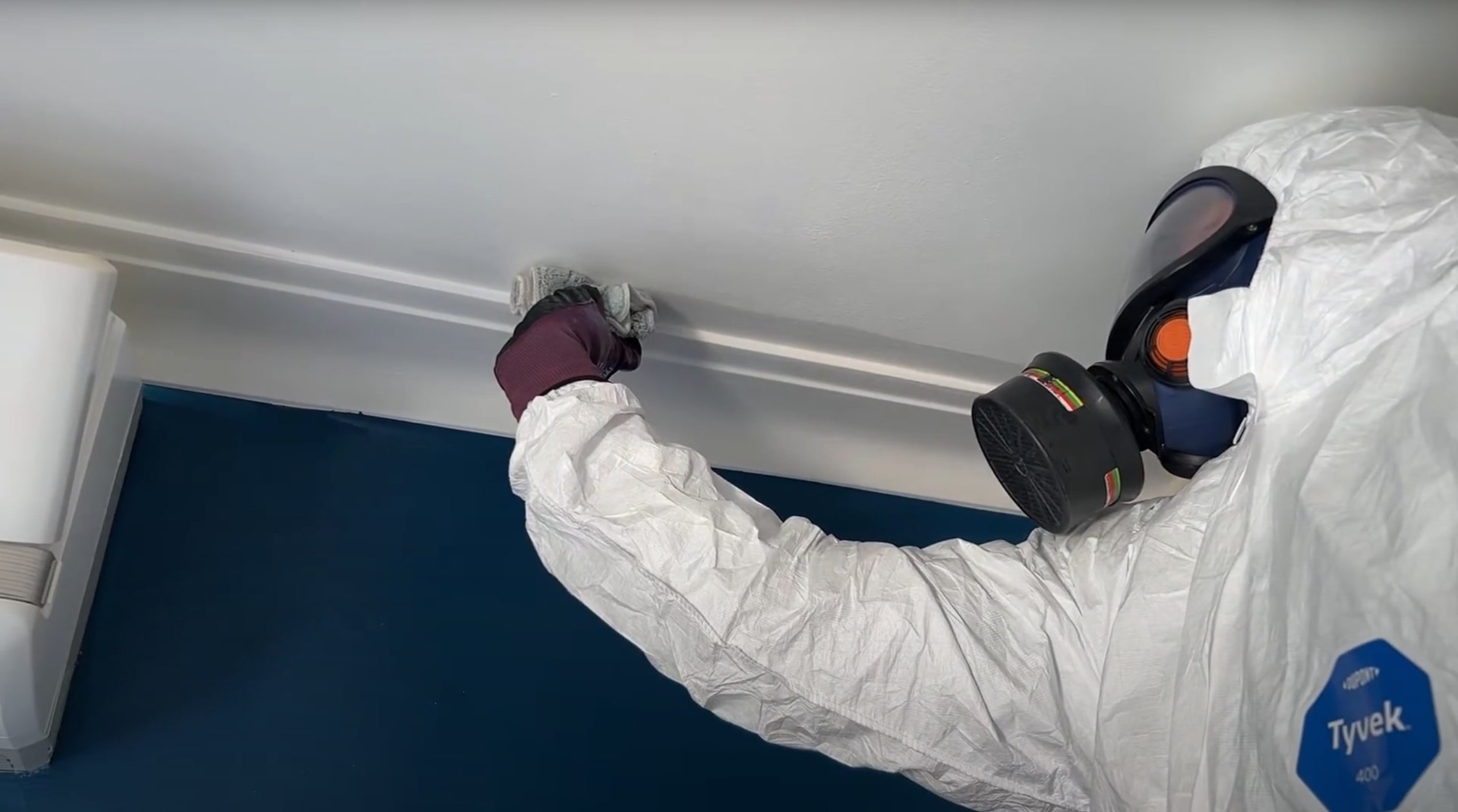 Mold remediation specialists in full protective equipment including respirators and hazmat suits performing safe mold removal in Johns Creek property
