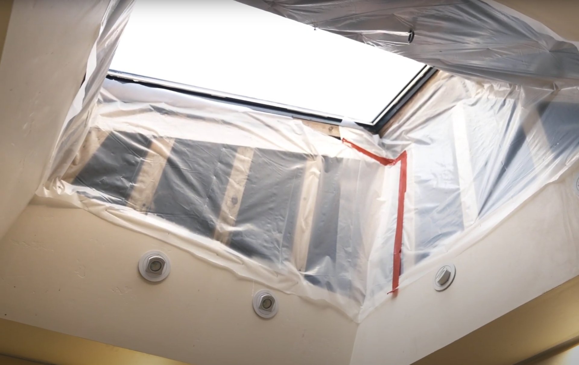 Professional water damage restoration technician working in contained environment with protective equipment